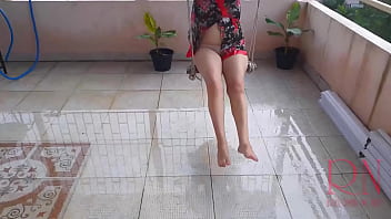 Summer rain in the garden. Naked nudist with a transparent umbrella on the terrace.  Cute housewife has fun without panties on the swing Slut swings and shows her perfect pussy